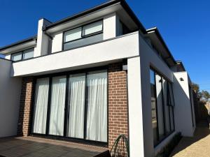 a house with large windows on a sunny day at New 2-story house with 4 bedrooms and 3 shower rooms in Burwood