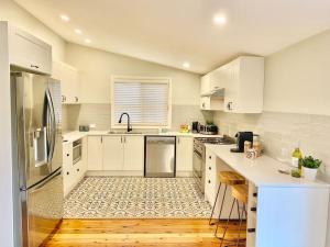 a kitchen with white cabinets and a counter top at Katoomba Cottage in Katoomba