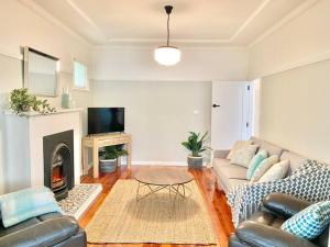 a living room with a couch and a fireplace at Katoomba Cottage in Katoomba
