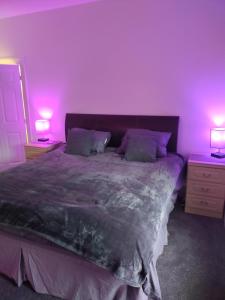 a bedroom with a large bed with purple lighting at Moden Stylish large Southsea Apartment with jacuzzi bath sleeps 6 in Portsmouth
