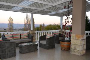 un portico con sedie e tavoli in vimini sul balcone di Mont d'Or Hotel Clarens a Clarens