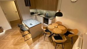 una pequeña cocina con mesa y sillas en una habitación en ApartamentLesznoPL Family Friendly, en Leszno