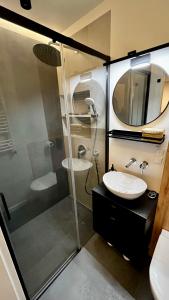 y baño con ducha acristalada y lavamanos. en ApartamentLesznoPL Family Friendly en Leszno