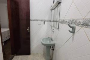 a bathroom with a sink on a wall at Casa no Centro de São Lourenço in São Lourenço