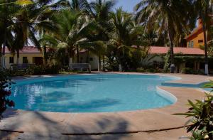 a large swimming pool with palm trees in the background at ESTUDIO 21 in Barra de Navidad