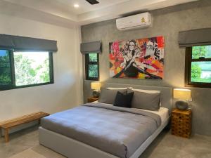 1 dormitorio con 1 cama y una pintura en la pared en PATAMAAN COTTAGES, en Nathon Bay