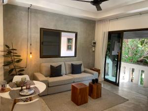 a living room with a couch and a table at PATAMAAN COTTAGES in Amphoe Koksamui