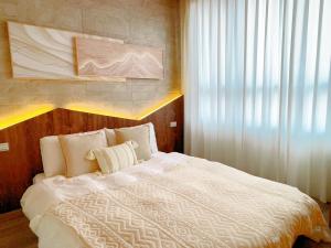 台南的住宿－台南悠然民宿unabnb，卧室配有白色的床和窗户。