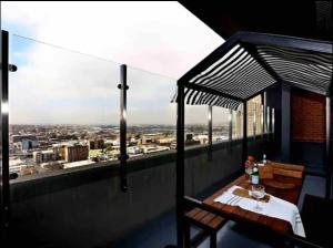 a balcony with a table and a view of a city at Skyline Serenade in Johannesburg
