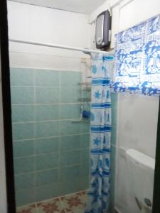 a bathroom with a shower with a blue shower curtain at Island Home in Honiara
