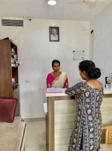 a woman is standing at a counter in a room at Lilly Ribera By Bestinn Leisure in Kumarakom