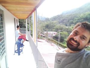 a man standing on the balcony of a house at HyH Estadía Gourmet in Ibagué