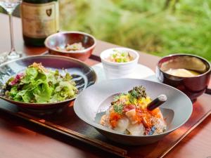 stół z dwoma miskami jedzenia i talerz sałatki w obiekcie The Royal Park Canvas Fukuoka Nakasu w mieście Fukuoka