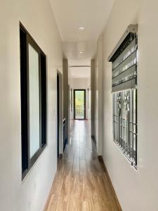 a hallway with white walls and a wooden floor at Êm Home 3 Phòng Ngủ in Hue
