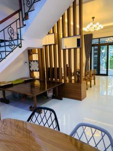a dining room with a table and a staircase at Êm Home 3 Phòng Ngủ in Hue