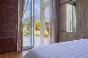 a bedroom with a bed and a sliding glass door at Villa Miracle Bedugul in Bedugul