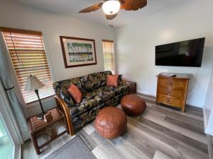 a living room with a couch and a flat screen tv at Hale O Malu at Kaloli Point in Keaau