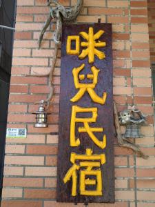 a sign on the side of a brick building at Mir Homestay in Lieyu