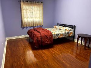 a bedroom with a bed and a wooden floor at Room for Rent Room 1 in Brampton