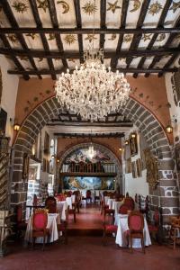 a dining room with tables and chairs and a chandelier at Inkarri Regocijo Plaza in Cusco