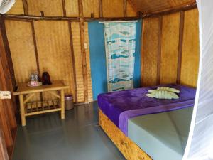 um pequeno quarto com uma cama e uma mesa em Andaman Bay Bungalow em Ko Lanta