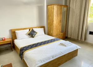 um quarto com uma cama grande e uma cabeceira em madeira em Khách Sạn Thiên Sơn em Cidade de Ho Chi Minh