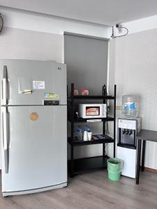 a kitchen with a white refrigerator and a shelf at 町宿溫泉旅館 in Jiaoxi