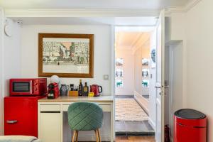 cocina con nevera roja y silla en Modern Apartement Grand Paris, TV Salon, Sharing Garden, Villa des Ammonites, en Meudon