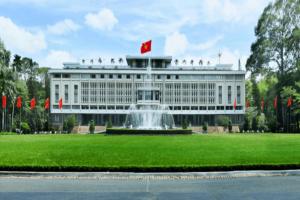 a white building with a fountain in front of it at Khách Sạn Thiên Sơn in Ho Chi Minh City