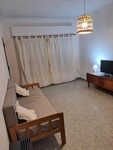 uma sala de estar com um sofá e uma televisão em Hostel Belgrano Home em Monte Grande