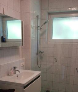 a bathroom with a shower and a sink and a mirror at Ferienhaus Roman in Hinterstoder