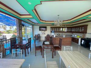a kitchen and dining room with wooden tables and chairs at Siargao By Grace Suites in General Luna