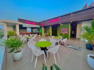 eine Terrasse mit einem grünen Tisch und Stühlen in einem Restaurant in der Unterkunft Ganges Blossam, Haridwar-Rishikesh Road - A Four Star Luxury Hotel in Rishikesh