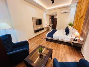 ein Schlafzimmer mit einem Bett und ein Wohnzimmer in der Unterkunft Ganges Blossam, Haridwar-Rishikesh Road - A Four Star Luxury Hotel in Rishikesh