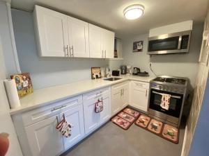 a kitchen with white cabinets and a stove at Cute Cozy 1 bedroom apartment 4 peoples 20 minutes to New York City in North Bergen