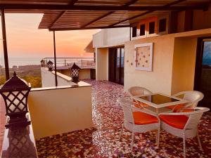 een patio met stoelen en een tafel op een balkon bij Fanta Sea Vacation Stay - 2 Bhk with private Terrace Flat in Ganpatipule