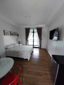 1 dormitorio con 2 camas, mesa y TV en Regal425 Condotel en Ángeles