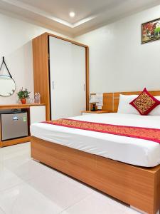a bedroom with a large bed and a tv at Sail Hotel Hạ Long in Ha Long