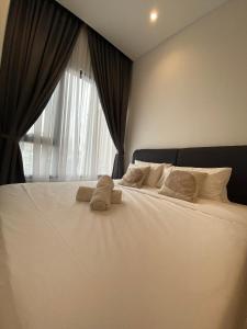 a large white bed with two stuffed animals on it at Infinity Pool Suite Bukit Bintang Lalaport BBCC Kuala Lumpur in Kuala Lumpur