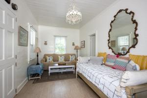 a living room with a bed and a mirror at Watercolor home in Harbour Island