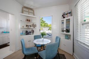 a dining room with a table and blue chairs at Watercolor home in Harbour Island