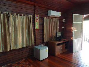 a room with a television and a desk with a computer at RuysukJo Resort&Pool in Udon Thani