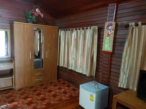 um quarto com painéis de madeira e um quarto com uma televisão em RuysukJo Resort&Pool em Udon Thani