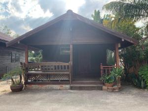 a small house with a porch and a bench at RuysukJo Resort&Pool in Udon Thani