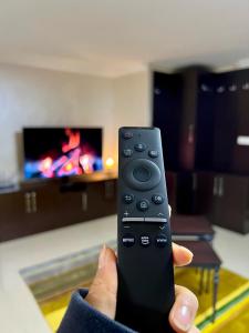 a person holding a remote control in a living room at NEW Seaview Bachelor Apartment Privacy + Closets in Mudanya