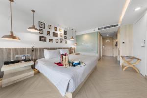 een slaapkamer met een groot wit bed met een bord erop bij Golden Tulip Pattaya Beach Resort in Noord Pattaya