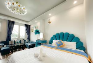 une chambre avec un grand lit et une tête de lit bleue dans l'établissement Huong Mai Hotel, à Đà Lạt