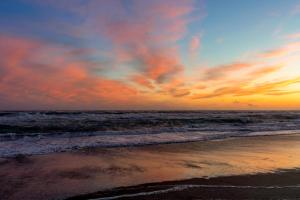 einen Sonnenuntergang am Strand mit dem Meer in der Unterkunft Gitavillage Club degli Amici in Pescia Romana