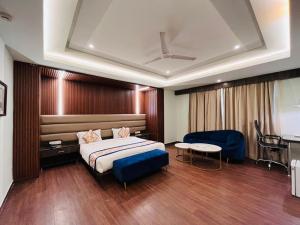 a hotel room with a bed and a table at Hotel Myriad in Lucknow
