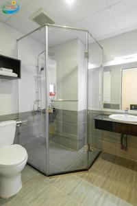 y baño con ducha, aseo y lavamanos. en Hoang Minh Chau Ba Trieu Hotel, en Da Lat
